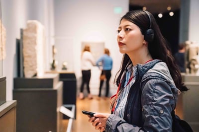 A female tourist in an art gallery using NFC tag sticker
