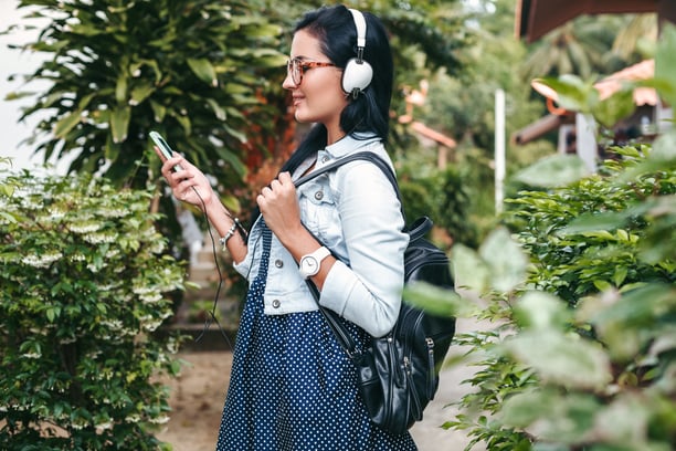 young-beautiful-stylish-woman-using-smartphone-headphones-eye-glasses-summer-vintage-denim-outfit-smiling-happy-positive