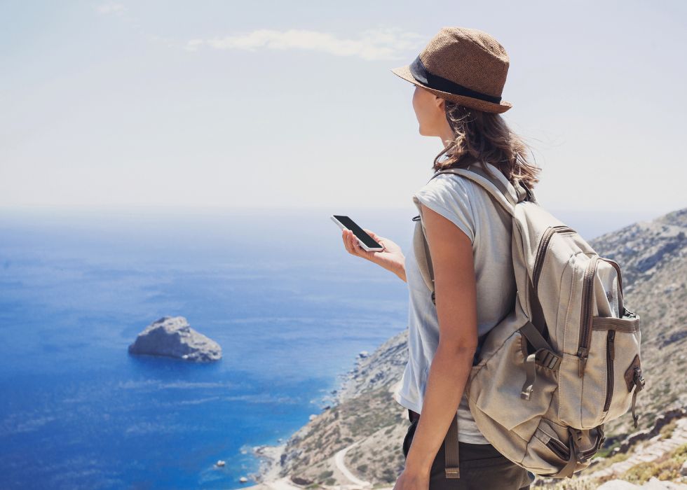 A girl using SmartGuide app on her phone while on self-guided tours. Example of sustainable tourism