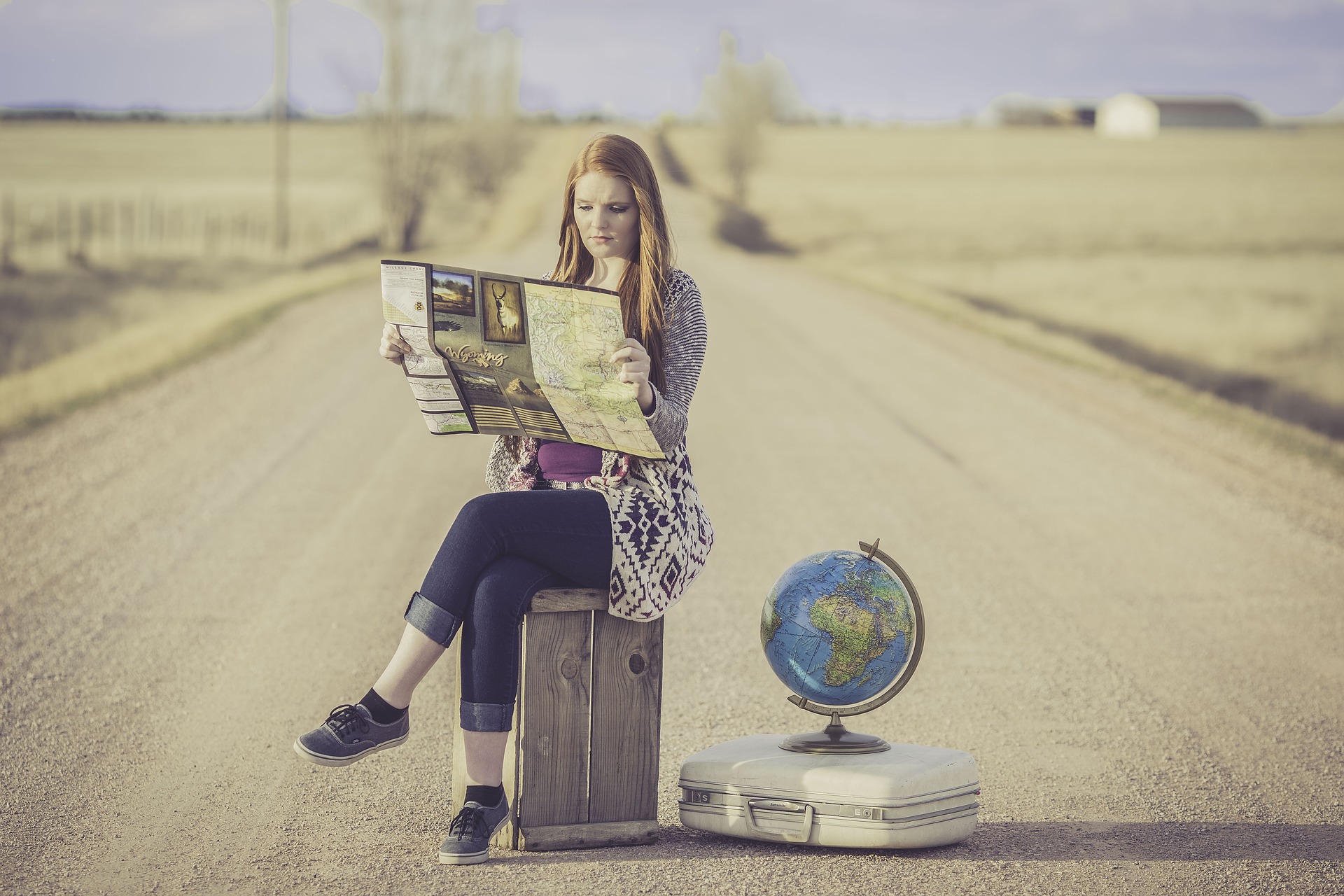 A girl reading a paper guide while touring the world is not amongst the top travel trends of 2022